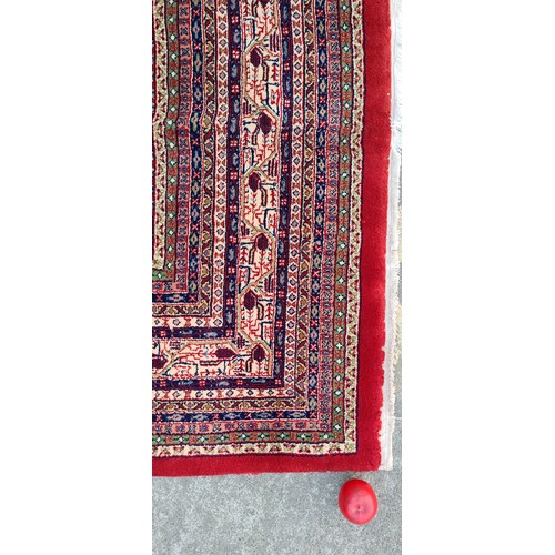 732 - Star Lot : A huge gorgeous hand knotted wool rug in a ruby red shade with an intricate geometric and... 