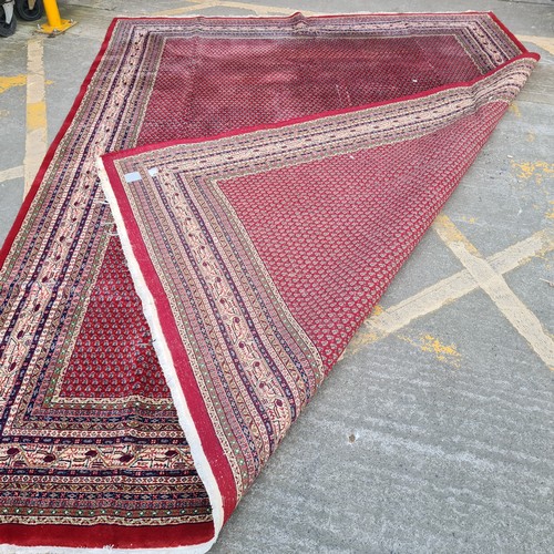 732 - Star Lot : A huge gorgeous hand knotted wool rug in a ruby red shade with an intricate geometric and... 