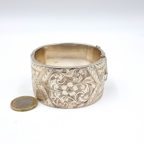 589 - A rare heavy quality vintage sterling silver bangle hallmarked Birmingham with finely detailed scrol... 