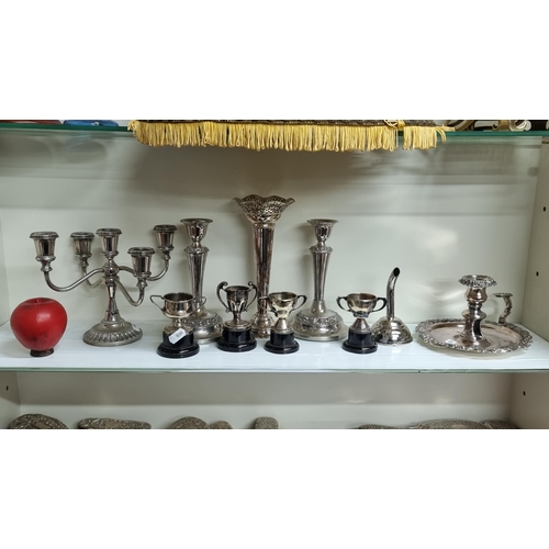 743 - A large collection of silver plate items including candlesticks and miniature trophies.