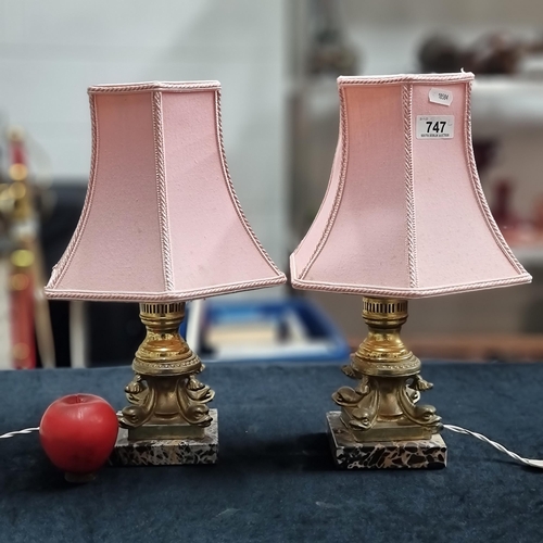 747 - A pair of vintage brass toned table lamps with plush pink shades and heavy marble bases. In good ord... 