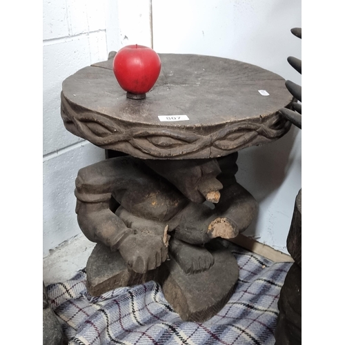 807 - A wonderful hand carved African wooden side table / stool, with stem in the form of a crouched figur... 