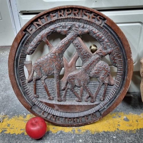 821 - A hand carved African round wooden wall plaque reading 