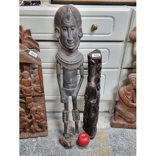 824 - Two antique and very heavy hand carved African wooden sculptures, the first featuring a figurative g... 