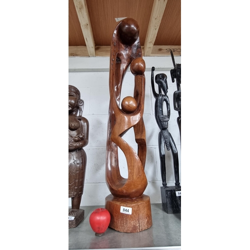 844 - A large and heavy hand carved mahogany sculpture featuring an abstracted family group of three figur... 