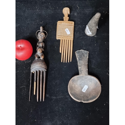 885 - A selection of four original African items including a Chokwe African comb surmounted by a character... 