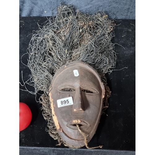 895 - Star lot An antique tribal  Lega Bwami mask featuring a simple, abstract shape of face with almond s... 