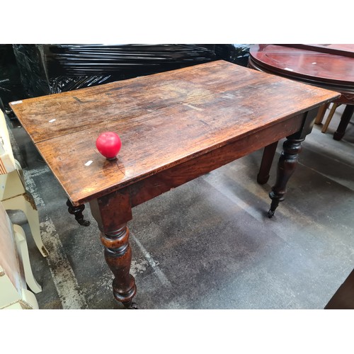 956 - A charming Victorian breakfast table with profusely turned legs set on castors.