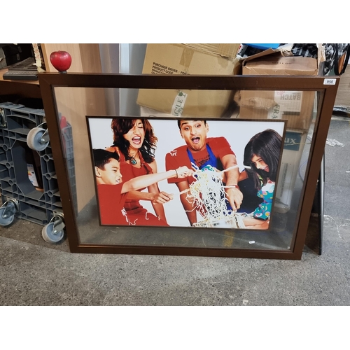 950 - A large good quality photograph of a happy family cooking together. Held in a stylish frame with gla... 