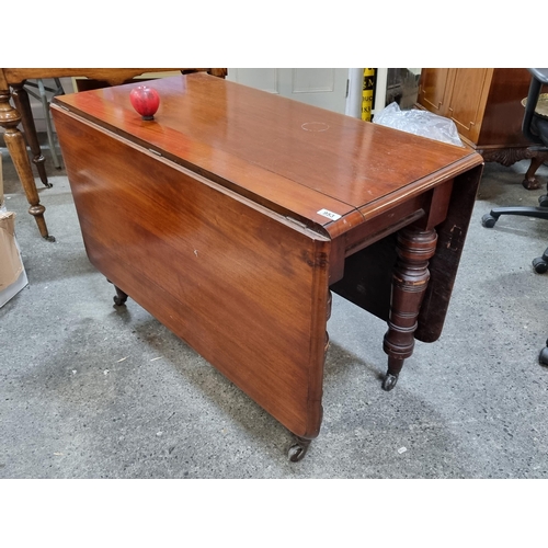 953 - Star Lot : An elegant Victorian drop leaf table with profusely turned legs held on original ceramic ... 