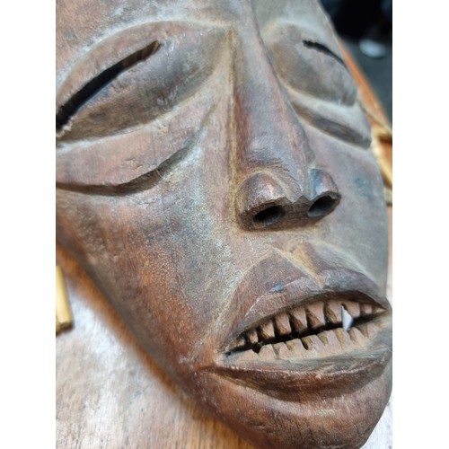 884 - An antique tribal hand carved African Chokwe mask, originating to Angola. The mask depicts a young w... 