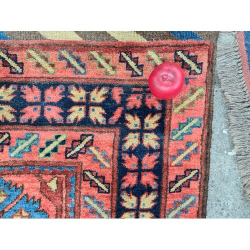 990 - Star Lot : An eyecatching hand knotted woolen rug featuring a bright floral pattern in a diverse col... 