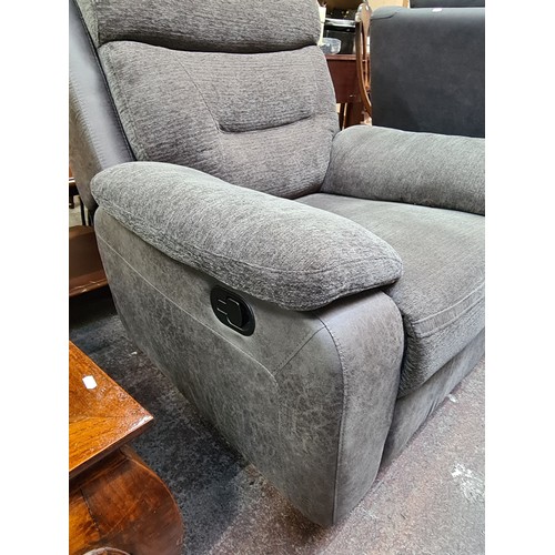 407 - Star Lot : A leather and fabric comfortable recliner armchair in a charcoal grey finish. This is in ... 