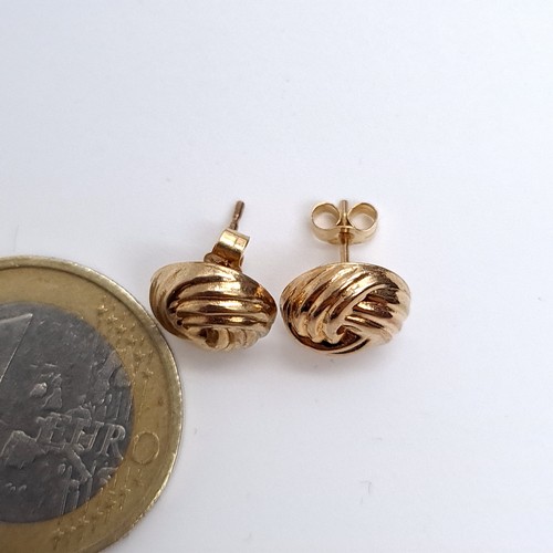 16 - A pair of 9ct gold stud earrings with twist style settings. Boxed marked 9ct. <1g