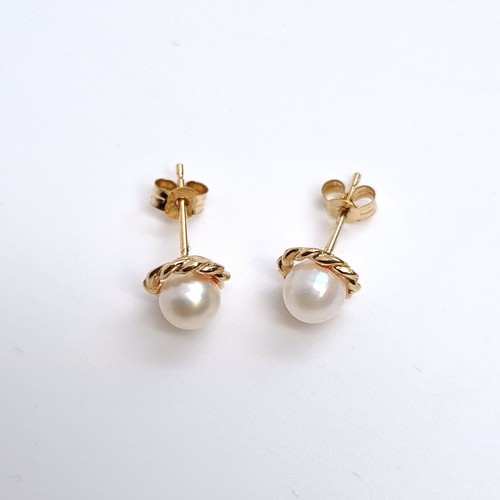 22 - A pair of 9K gold pearl earrings set with rope twist mounts, weight 1.22 grams. Boxed.