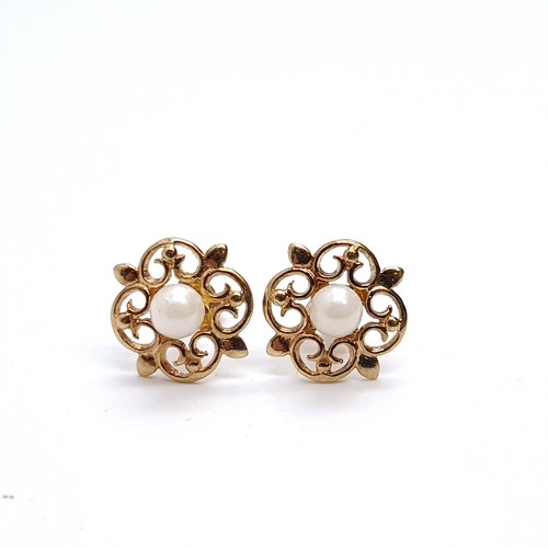 28 - A pair of vintage pearl set 9K gold stud earrings with scroll design mounts, weight 1.14 grams. Boxe... 