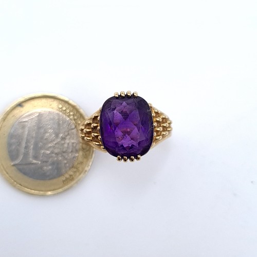 517 - Star Lot : A very fine quality example of a heavy 9K gold amethyst stone ring with raise shoulders, ... 