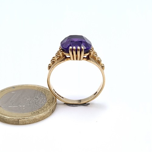 517 - Star Lot : A very fine quality example of a heavy 9K gold amethyst stone ring with raise shoulders, ... 