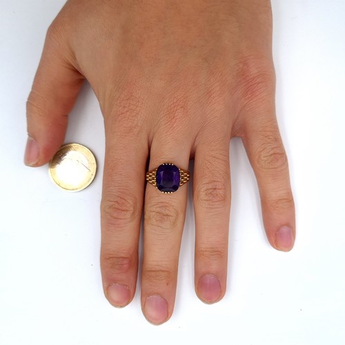 517 - Star Lot : A very fine quality example of a heavy 9K gold amethyst stone ring with raise shoulders, ... 