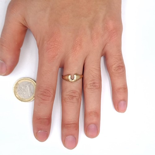 548 - An interesting and unusual 9K gold ring with a cutout form in the shape of a horse shoe, size O, wei... 