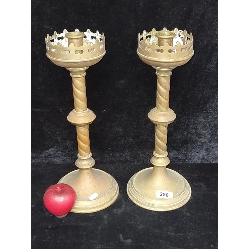 250 - Two elegant antique church brass candlesticks featuring ornate crown-shaped wax catcher holders, per... 