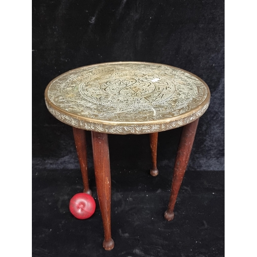 252 - Intricate brass-topped  table with fabulous etchings, complemented by rich mahogany legs. A piece st... 