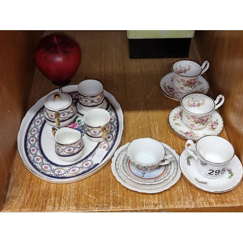 295 - A vintage minature porcelain tea set with floral motifs and gold accents, offering a touch of nostal... 