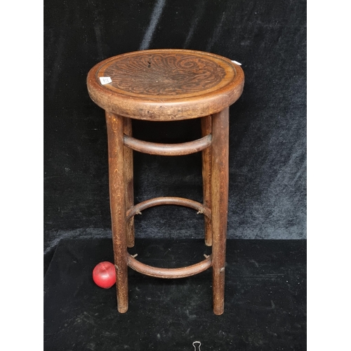 323 - A vintage bentwood stool boasting intricate carving to the seat.