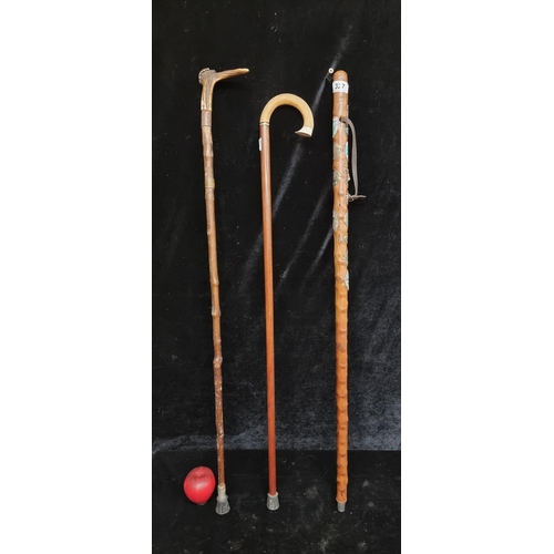 327 - A selection of three vintage walking sticks, including a Swiss hiking stick with a number of badges,... 