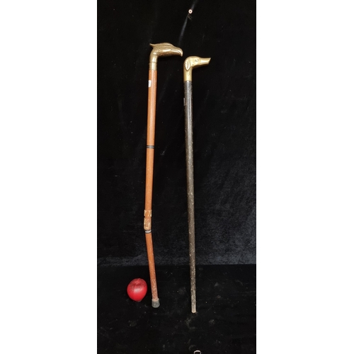 328 - Two gentleman's walking sticks; one with a brass-toned eagle head handle and the other featuring a b... 