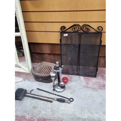 434 - Vintage fireplace ensemble featuring a cast iron grate, ornamental screen, and four fireplace tools.... 