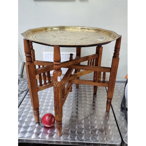 463 - A Six leg folding Moroccan table with brass top in good condition.