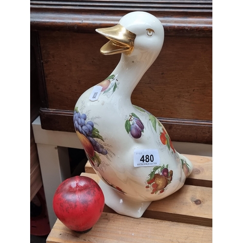 480 - Ornate ceramic duck, adorned with a lustrous fruit motif, featuring a golden beak – a delightful col... 