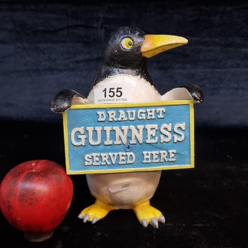 A Guinness figure of a penguin holding an advertising plaque.