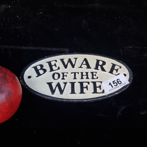 156 - An oval cast metal plaque reading 'Beware of the Wife'.