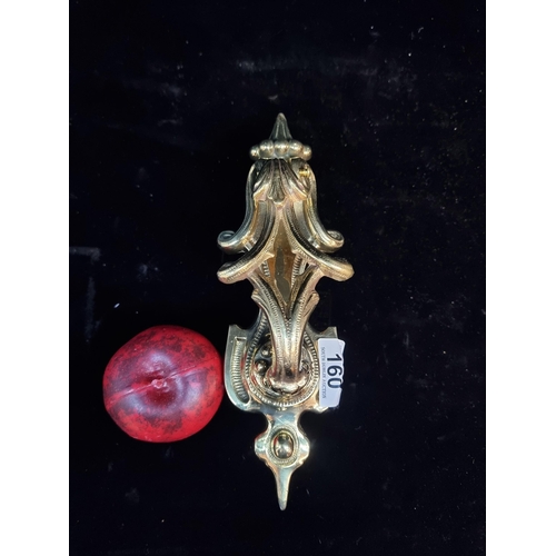 160 - A very ornate brass door knocker with scroll detailing and fittings.