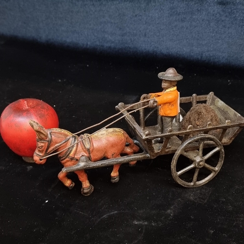 171 - A vintage heavy cast metal toy donkey drawn wagon carrying turf/mud. With rotating wheels.