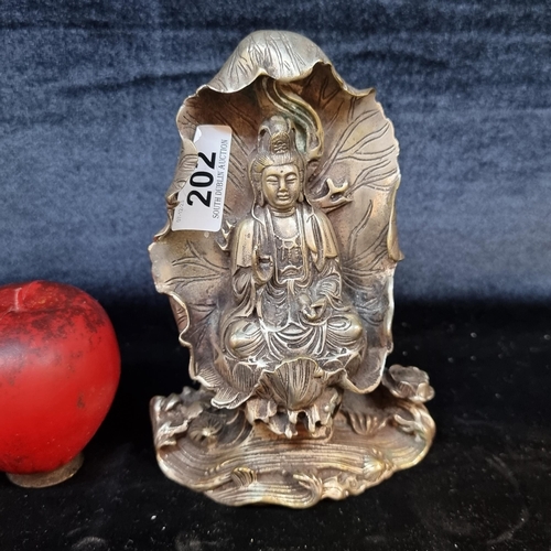 202 - A stunning vintage  chrome over brass figure of Guaryin sitting on a large lotus leaf.