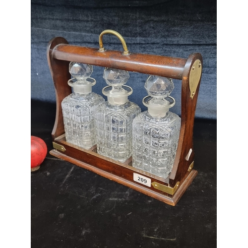 209 - A fabulous antique Victorian tantalus with three matching decanters in good order.  and brass hardwa... 