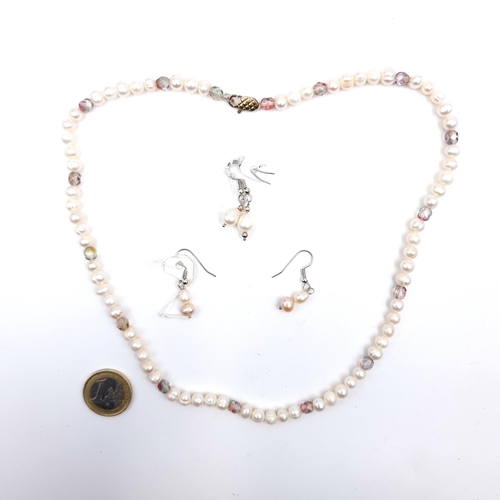 528 - A natural fresh water pearl necklace with crystal set accents together with two pairs of pearl stud ... 