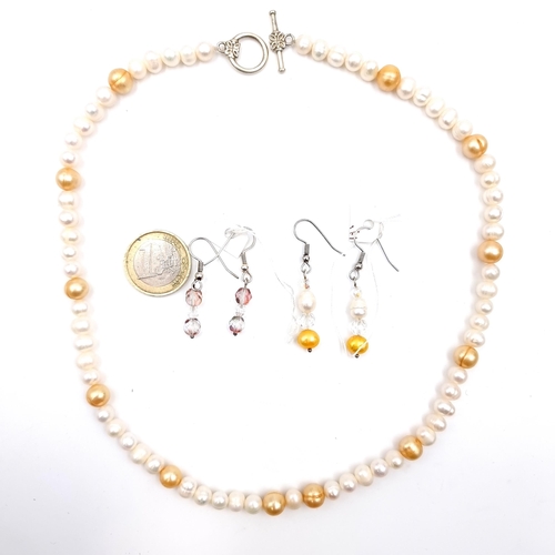 534 - A graduated natural fresh water pearl necklace set with gold pearl accents with t-bar clasp, length ... 