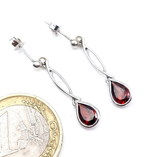 555 - A very pretty pair of 9K white gold garnet stone drop earrings, hallmark stamped to post, weight 1.6... 