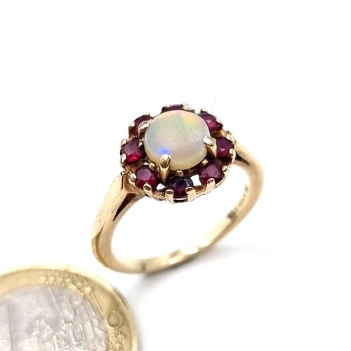 561 - Star Lot : A vintage opal stone ring with a ruby cluster surround mounted on 14K gold (stamped to ba... 