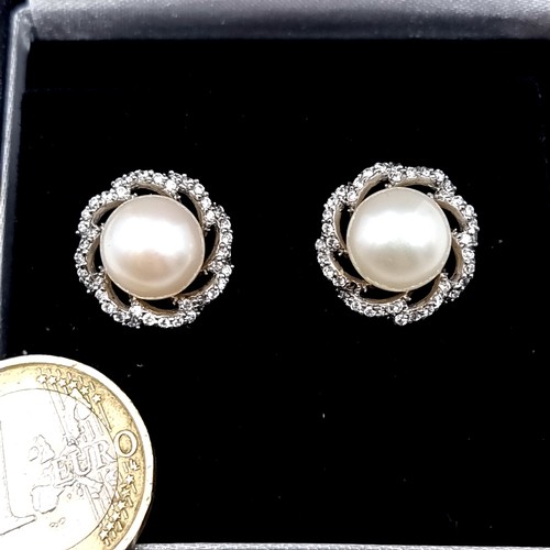 564 - Star Lot : A pair of outstanding pearl stud earrings mounted on 9K white gold set with a diamond hal... 