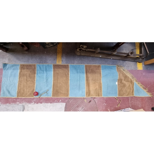 575 - A large and long heraldic banner finished with a fringe trim and featuring a tactile beige and turqu... 