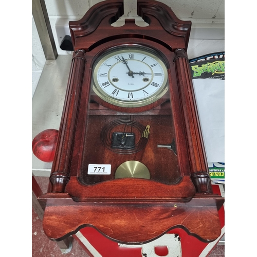 771 - A handsome 31 day chiming clock with a timeless carved wooden frame, pendulum and winding key.