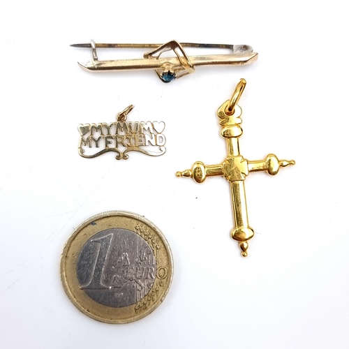 891 - Three gold jewellery items including a 9K gold aquamarine set brooch, pin still intact, a crucifix p... 