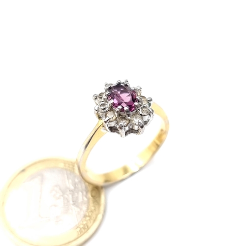 895 - A lovely 9k gold gem set ring with a purple central stone with a cluster surround, stamped 