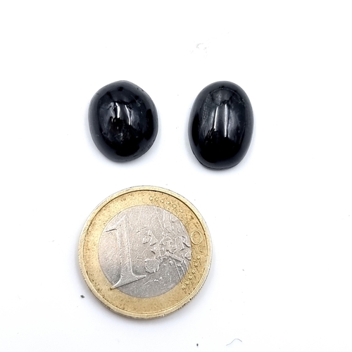 928 - Two star sapphire cabochon stones, total weight 4.7 grams. Stunning dark blue colour. Cold to the to... 