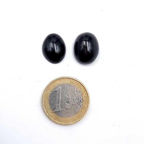 933 - Two stunning cabochon star sapphire stones. Cold to the touch and a fabulous dark blue colour.